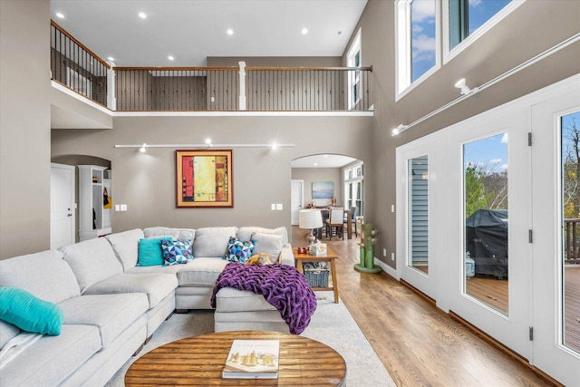 living room with a towering ceiling and light hardwood / wood-style flooring