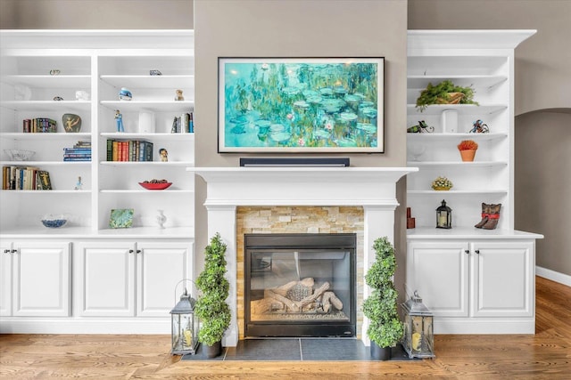 living room with a fireplace and light wood-type flooring