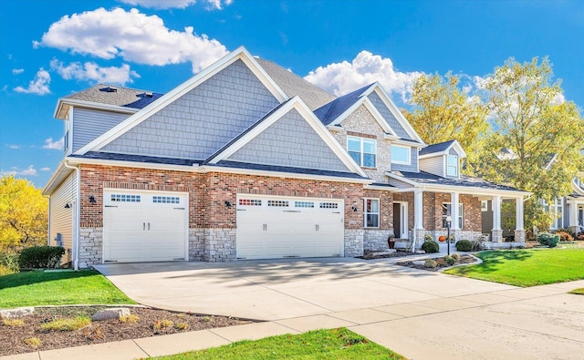 craftsman-style house with covered porch, a garage, and a front yard