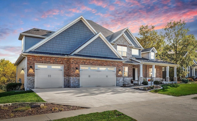 craftsman-style house with covered porch, a garage, and a yard