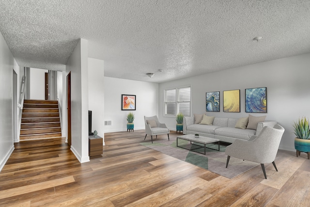 living room with hardwood / wood-style floors and a textured ceiling