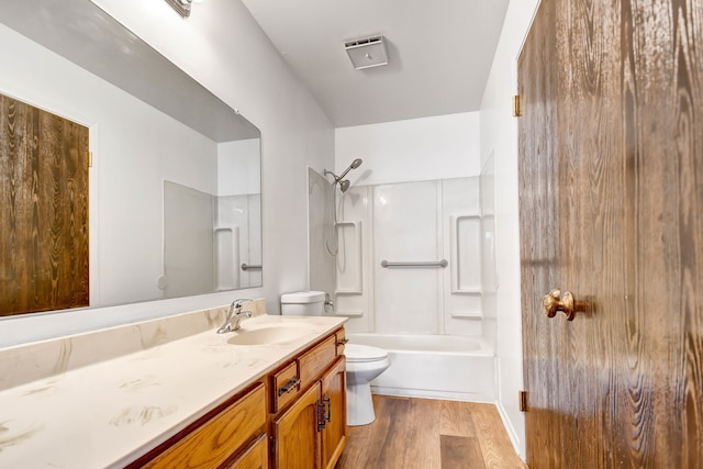 full bathroom with vanity, toilet, hardwood / wood-style flooring, and washtub / shower combination