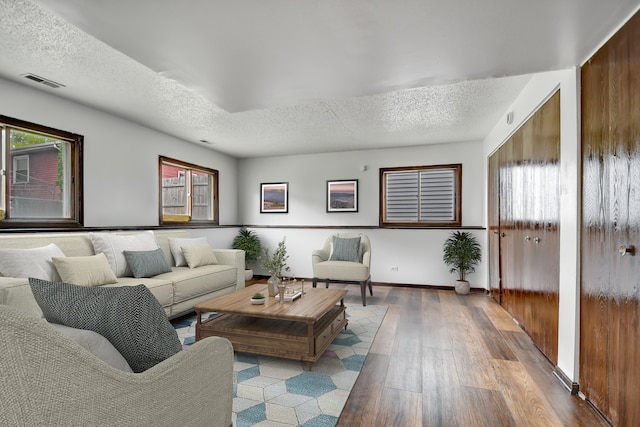 living room with hardwood / wood-style floors and a textured ceiling