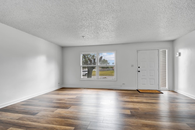 entrance foyer with a textured ceiling and dark hardwood / wood-style floors