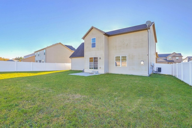 back of house with central AC, a patio area, and a lawn