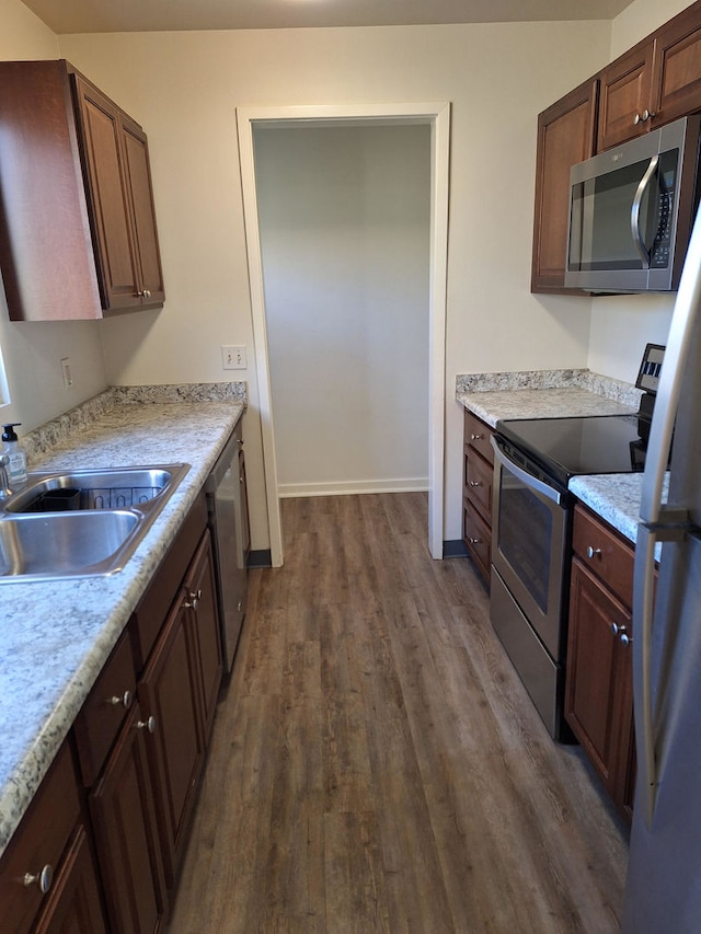 kitchen with stainless steel appliances, sink, and dark hardwood / wood-style floors