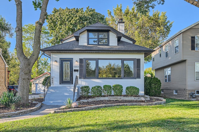 view of front of home with a garage and a front lawn