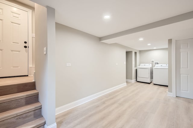 basement featuring washer and clothes dryer and light wood-type flooring