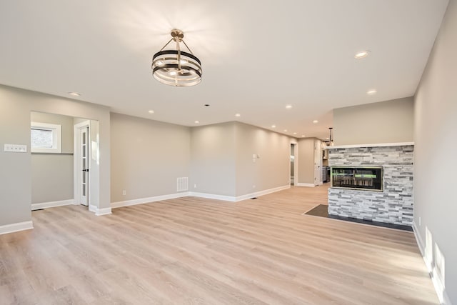 unfurnished living room with a fireplace and light wood-type flooring