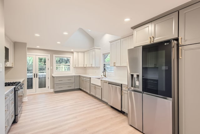 kitchen featuring french doors, stainless steel appliances, sink, light wood-type flooring, and gray cabinets