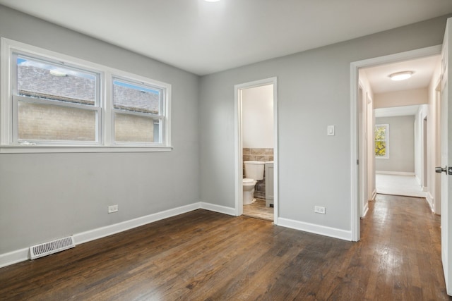 unfurnished bedroom with dark hardwood / wood-style flooring and ensuite bathroom