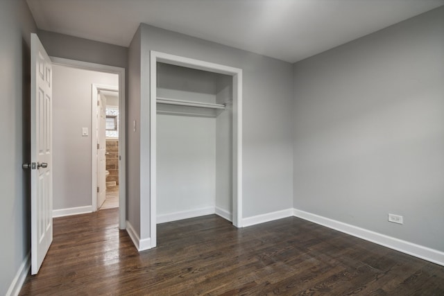 unfurnished bedroom featuring dark hardwood / wood-style floors and a closet