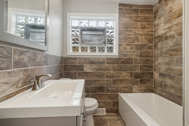 full bathroom with vanity, toilet, tile walls, and bathing tub / shower combination