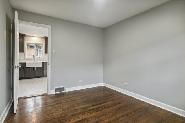 empty room featuring sink and hardwood / wood-style flooring