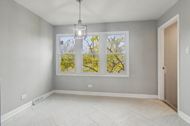 unfurnished dining area featuring a notable chandelier