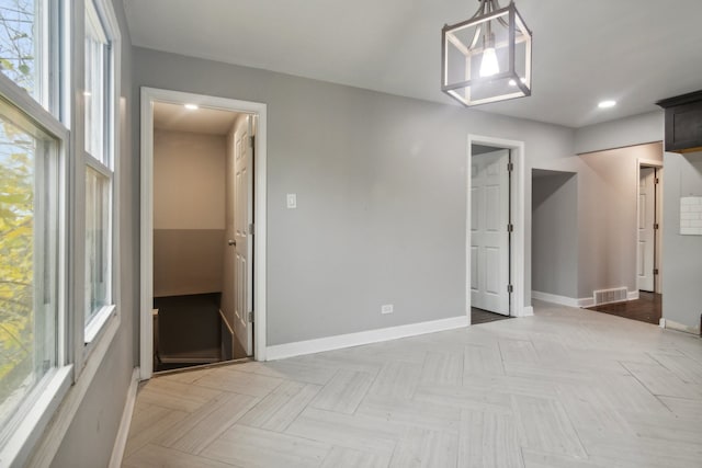 interior space with light parquet flooring and an inviting chandelier