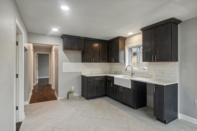 kitchen featuring decorative backsplash, sink, and dark brown cabinets