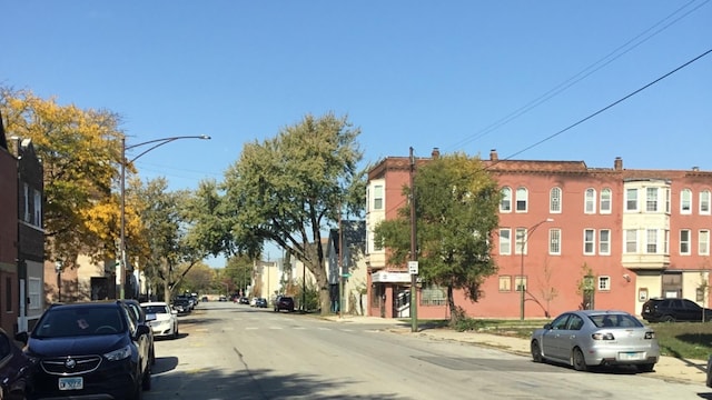 view of asphalt street with street lights, sidewalks, and curbs