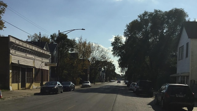 view of asphalt road with street lights, sidewalks, and curbs
