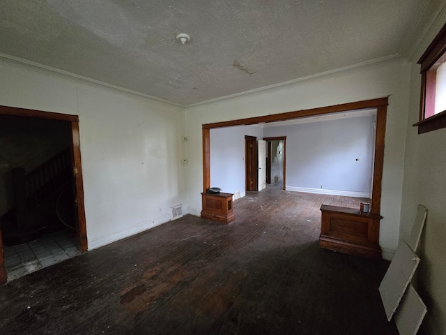 unfurnished living room featuring ornamental molding, a textured ceiling, and dark hardwood / wood-style floors