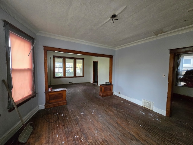 unfurnished living room with dark hardwood / wood-style floors, a textured ceiling, and ornamental molding