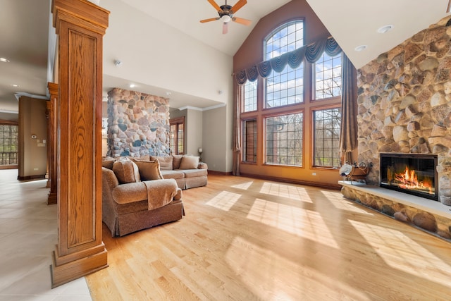 living room with a fireplace, ceiling fan, crown molding, high vaulted ceiling, and light hardwood / wood-style flooring