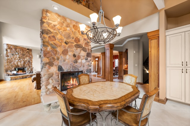 tiled dining room with decorative columns and a fireplace