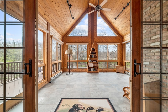 unfurnished sunroom featuring lofted ceiling, a baseboard heating unit, ceiling fan, and wooden ceiling