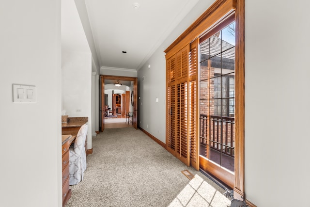 corridor with crown molding and carpet flooring