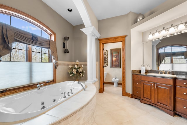 bathroom featuring vanity, decorative columns, a bidet, and a relaxing tiled tub