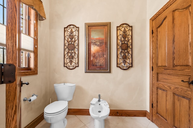 bathroom featuring toilet, tile patterned floors, and a bidet