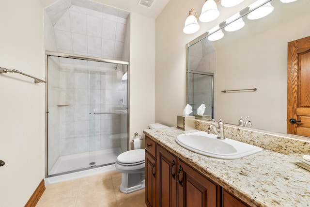 bathroom featuring toilet, a shower with shower door, vanity, and tile patterned floors