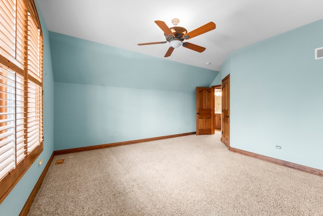 additional living space featuring ceiling fan, vaulted ceiling, and light colored carpet