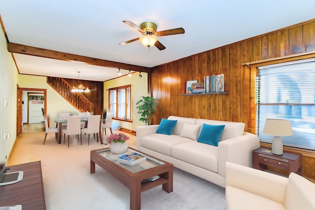 carpeted living room with plenty of natural light, wooden walls, and beamed ceiling