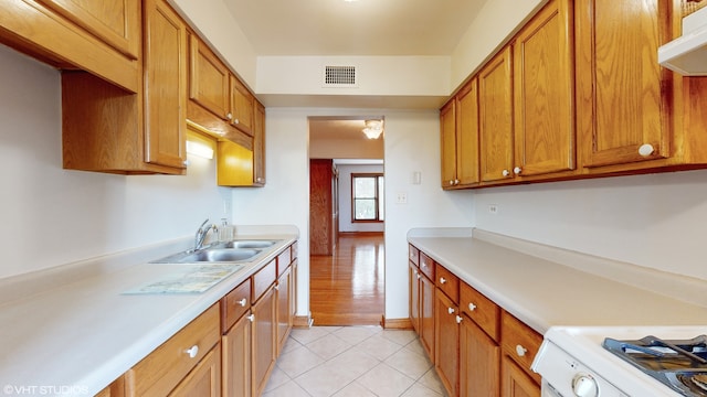 kitchen with white range oven, exhaust hood, sink, and light wood-type flooring