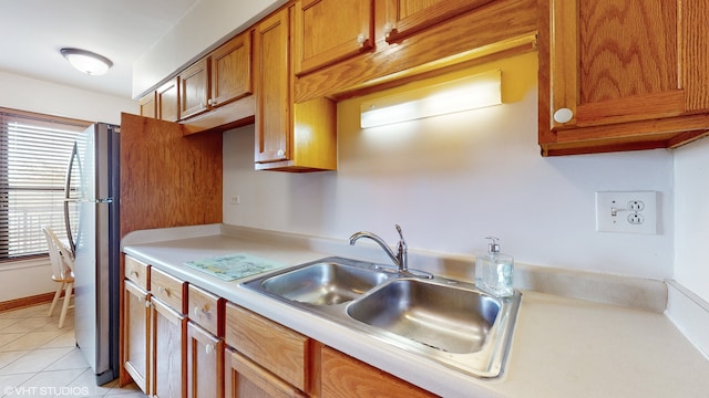 kitchen with sink, stainless steel refrigerator, and light tile patterned floors