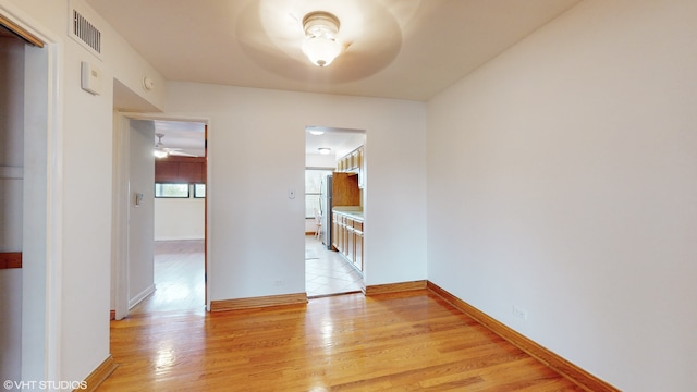 empty room with ceiling fan and light wood-type flooring