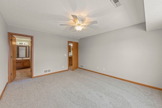 unfurnished bedroom with light carpet, connected bathroom, and ceiling fan