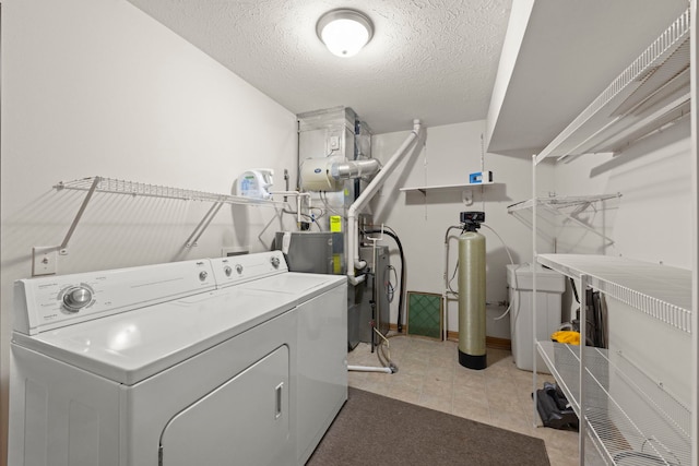 washroom featuring washing machine and dryer and a textured ceiling