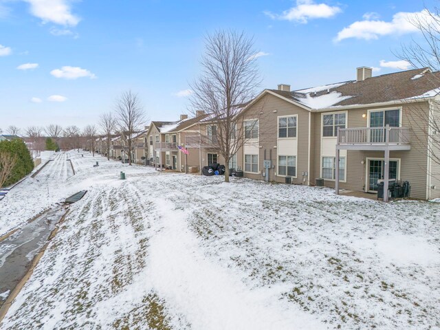 yard covered in snow with a balcony