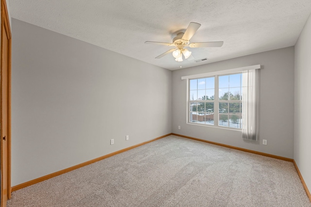 unfurnished room featuring carpet flooring, ceiling fan, and a textured ceiling