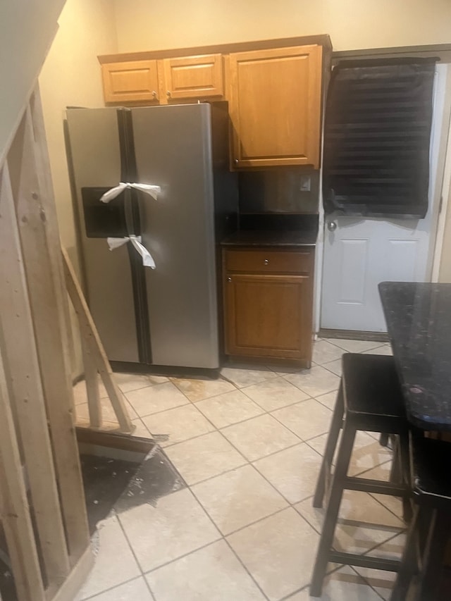 kitchen featuring light tile patterned flooring and stainless steel fridge with ice dispenser