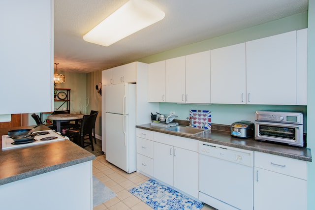 kitchen featuring white appliances, sink, a textured ceiling, white cabinetry, and a chandelier