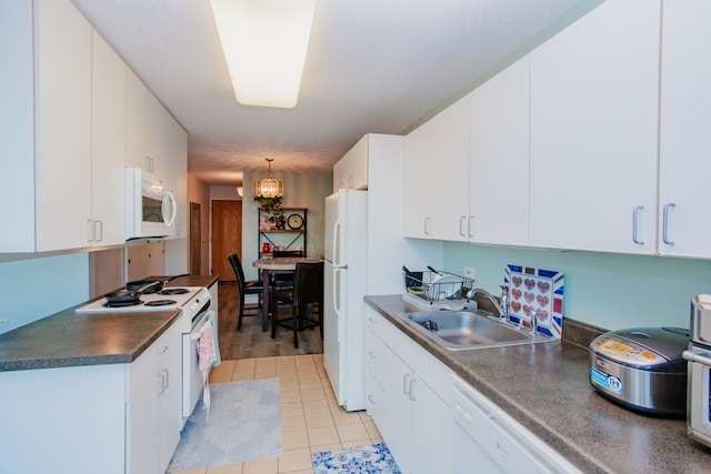 kitchen featuring sink, white cabinets, hanging light fixtures, and white appliances