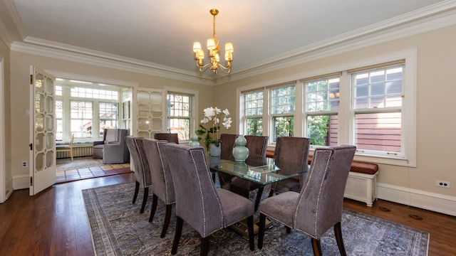 dining room featuring dark wood-type flooring, ornamental molding, and a chandelier