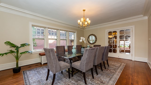 dining space featuring ornamental molding, dark hardwood / wood-style floors, a notable chandelier, and french doors