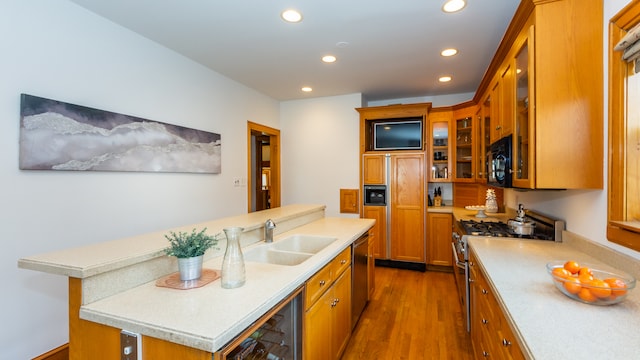 kitchen featuring dark wood-type flooring, sink, dishwasher, a kitchen island with sink, and high end stove