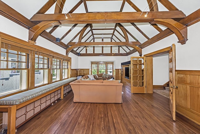 living room featuring dark wood-type flooring and vaulted ceiling with beams