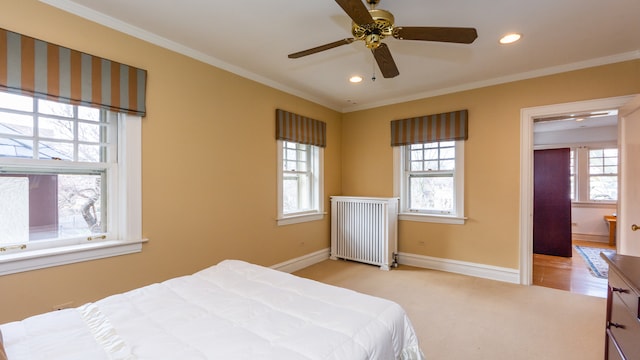 carpeted bedroom featuring multiple windows, crown molding, and radiator heating unit