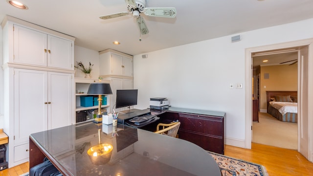 home office with ceiling fan and light hardwood / wood-style flooring